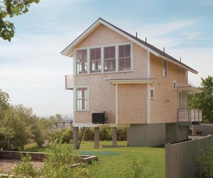 Perching above flood-prone shores, this 1,440-square-foot cottage makes efficient use of its narrow site, provides privacy by grouping service spaces along its street side, and positions living areas to take advantage of spectacular views.