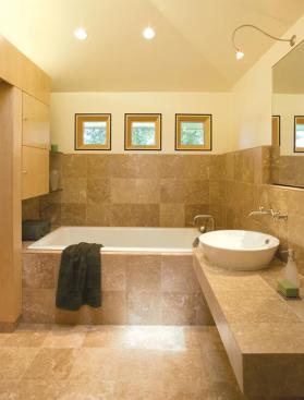 The design for this bathroom/closet renovation included bumping up ceiling heights and swathing surfaces in neutral-toned, natural materials to create a serene, modern, and unified environment.