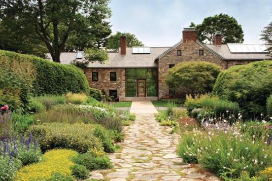 This sprawling stone farmhouse is one of 14 buildings on 640 acres of land in Pennsylvania. The reconfigured main house blends existing structural elements with salvaged and regional materials.