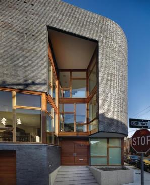 Brick walls, mahogany windows, sapele siding, and the sandblasted concrete entry platform are a twist on traditional neighborhood materials.