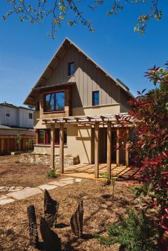 A 5-kW PV array, set at the rear of the roof to avoid shading from street trees, is designed to bring the house to net-zero energy and charge an electric car. The system includes micro inverters, rather than the standard single large inverter, to minimize temporary shading effects from clouds. It's estimated to increase energy production by 15% and reduce the required number of PV panels on the roof.
