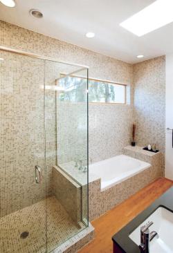 Mosaic glass tiles cover the linear bathing areas in the master bath. Their random pattern enlivens the otherwise subdued hues. Other materials, including bamboo floors and birch cabinets, mimic the kitchen palette.