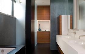 A Corian sink counter inserts an island-like element between the master bedroom and bath.