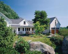 A new barn/garage and a reworked ell shift the focus of this house toward a lushly landscaped side yard.