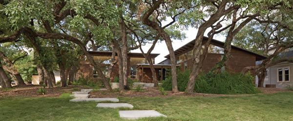 Siting of Hacienda Ja Ja protected the existing live oak trees, while drought-tolerant plantings, native buffalograss, and permeable walkways reduce landscape water needs supplied by the 6,000-gallon rainwater catchment system. 