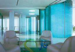 Three stories high and 75 feet long, this "curtain" of stacked glass winds through a building that houses both living quarters and a private museum.