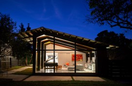 A custom steel and glass system transformed the garage into a jewel box of a living room extending the interior space to the outdoor landscape.