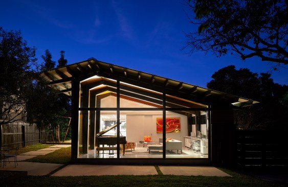 A custom steel and glass system transformed the garage into a jewel box of a living room extending the interior space to the outdoor landscape. 