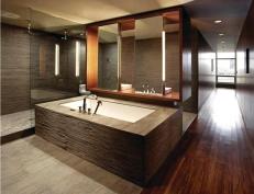With its open layout and glass partitions, this master bath makes the most of daylight borrowed from a distant bedroom window.