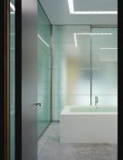 Symmetrical layers of acid-etched glass provide a measure of privacy and soften the look both inside and outside the master bath.