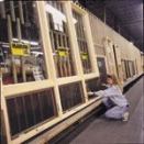 A Marvin Window and Doors employee checks the width of a new wall of windows being prepared for sale.