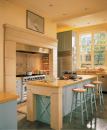 An acid-stained concrete floor and a coffered ceiling unite the kitchen and family room. The detailing on the side of the island is repeated on the fireplace.