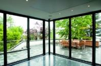 The honed granite floor changes textures around the perimeter of the room to signal the glass wall. A steel column blends into the framing while supporting the concrete floor of the second story.