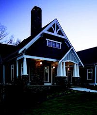 CRAFTY HOMAGE: A Georgia home by Peek Design features the rustic stone, shingling, and 1½-story stature typically found in traditional Craftsman bungalows.