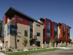 RUDDY GLOW: Boulder Street Townhomes' red panels—made of wood-veneer phenolic resin—warm the brick-and-stucco façade, creating a bright spot in a formerly industrial neighborhood. Below, light from inside makes a dramatic profile more striking.