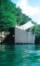 The boat dock's wall of steel tubes and stretched fabric roof lend it a feeling of lightness and transparency.