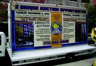 STREET MARKETING: Aggressive marketing, such as this rolling billboard, is common  before a real estate auction.