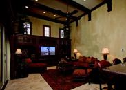 PIVOTAL POINTS: Walls aren't used to delineate spatial transitions from one room to the next in this open floor plan.  Here, the passage from family room to kitchen (below)  is marked by a bi-level wet bar and a change in ceiling heights.  The kitchen's 12-foot volume space bumps up to a loftier 18-feet in the adjacent family room, where exposed wood beams provide texture and contrast.
