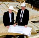 TOTAL COMMITMENT: John Crosland Jr., left, seen here with Bert Green, executive director of Habitat  for Humanity–Charlotte, N.C., has spearheaded countless projects  in his hometown—from affordable housing and education to the arts  and healthcare.