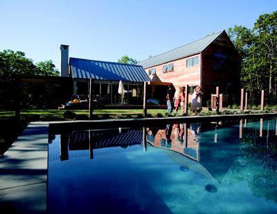OPEN WIDE: The home snuggles up to the northeastern property line, freeing up sight lines  in back to a 15-acre wooded reserve to the south and west. Inside, a skylight  above the stairwell (below) allows light to filter into the core of  the house.