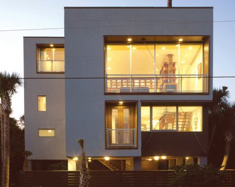 A cleverly crafted vertical storage-and-circulation spine unifies the multi-level living space of this narrow infill beach house.