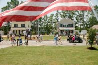 A flag waves from the porch of a newly completed Habitat house in Suffolk, Va., as visitors make their way to dedication ceremonies during Home Builders Blitz 2008.
