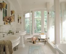 The sleek shower is the most mod fi xture in the bath. Crisp square columns support frameless glass walls that counter the rounded forms of period sinks and tub. The architects scoured Chicago’s antique shops for authentic fi ttings to match the owner’s collection, yet their simple layout of freestanding pieces speaks to contemporary living.