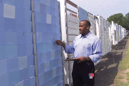 PAINT CHECK: Paint chemist Stewart O. Williams, Ph. D., inspects test samples at the Rohm and Haas long-term outdoor exposure facility in Pennsylvania.  Continued research has improved paint performance in recent years.