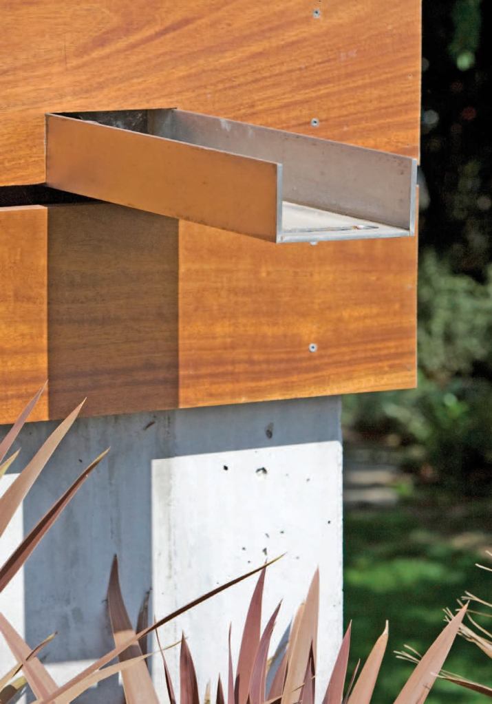 Stylish steel scuppers move water away from the 33 concrete piles (some as deep as 90 feet) that support the house and toward corner planting beds.