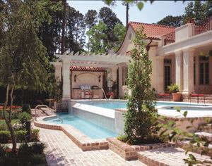 A new multipurpose pool house adds function and form to this backyard. Sited to block neighbors' views of the pool, as well as north winds, the structure provides a shaded place to gather, cook, and dine under its large, umbrellalike roof.