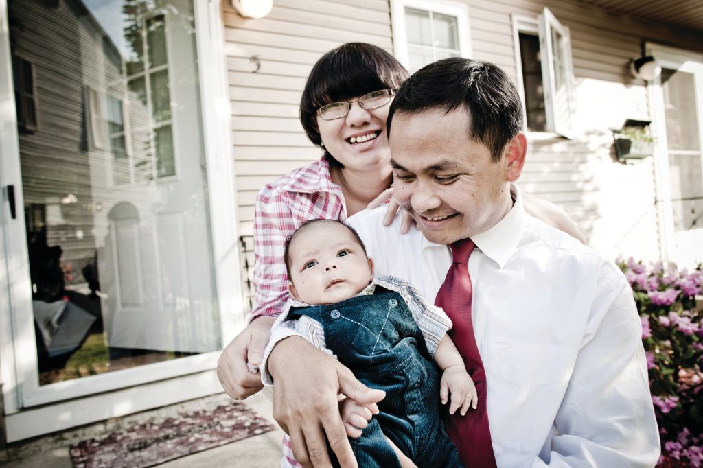 FINALLY ARRIVED: Cambodian-American Tooch Van, wife Chorvy, and son Winston, outside the Lowell, Mass., home they bought with help from a local housing group.