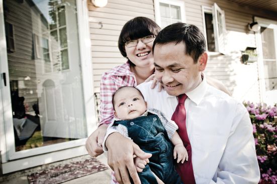 FINALLY ARRIVED: Cambodian-American Tooch Van, wife Chorvy, and son Winston, outside the Lowell, Mass., home they bought with help from a local housing group.