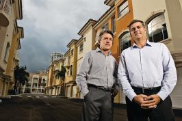 Frank Mackle (far right) and Venny Torre of Torre Mackle Group, standing in front of Terzetto Villas, a townhouse project in Miami they built out for Ocean Bank, which provided construction financing.