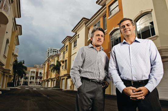 Frank Mackle (far right) and Venny Torre of Torre Mackle Group, standing in front of Terzetto Villas, a townhouse project in Miami they built out for Ocean Bank, which provided construction financing.