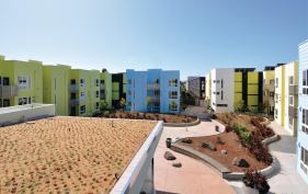 BRIGHT FUTURE: The colorful buildings of Ironhorse at Central Station surround an undulating courtyard that’s more plants than pavement and provide ample flat-roof surfaces for solar collectors and vegetation to offset operating costs and environmental impact.