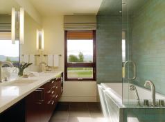 As in the master, the bathing area in the children's bath is defined by ceramic tile in a running bond pattern. The transparent shower surround occupies little apparent space, virtually disappearing against the darker tile.