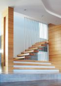 Stainless steel rods provide deceptively solid support for a stair that seems to float in space.