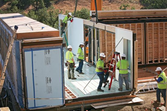 Labor Dispute. Workers assemble a home made from modules produced by Blu Homes, the California-based manufacturer that has run afoul of Carpenters Union Local 180, which accused the company of unfair labor practices.