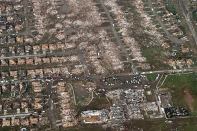 This aerial photo shows the remains of homes hit by a massive tornado in Moore, Okla., on Monday, May 20, 2013. A tornado roared through the Oklahoma City suburbs Monday, flattening entire neighborhoods, setting buildings on fire and landing a direct blow on an elementary school. (AP Photo/Steve Gooch)