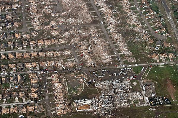 This aerial photo shows the remains of homes hit by a massive tornado in Moore, Okla., on Monday, May 20, 2013. A tornado roared through the Oklahoma City suburbs Monday, flattening entire neighborhoods, setting buildings on fire and landing a direct blow on an elementary school. (AP Photo/Steve Gooch)