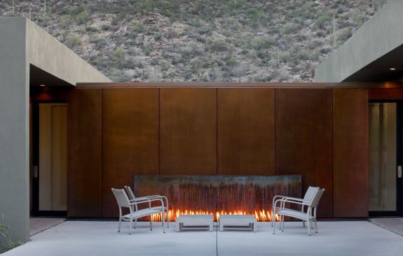 Reflecting the light and heat from those flames is the solid wall of the library connector space that is finished in clear-coated rusted steel