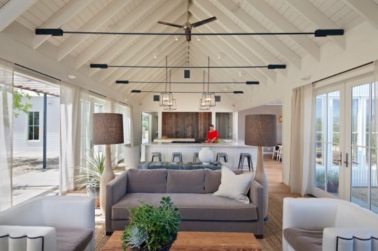 In this Sonoma County house-- Healdsburg Residence by Nick Noyes Architecture and Eddinger Enterprises--roof rafters align with window and door openings to create a lofty and cozy living room.