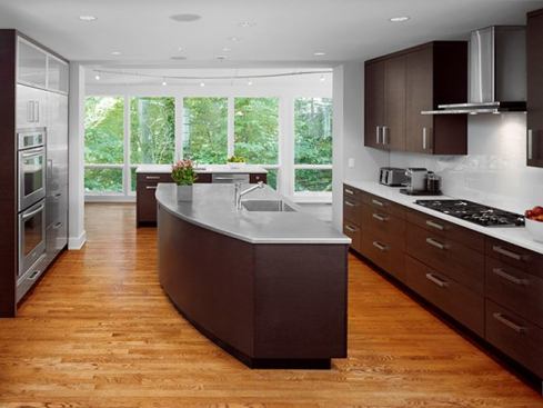 One side of the island is curved; which draws traffic into the kitchen while diverting it from the cooks space. There's a four-foot space between the wall ovens and the island--close enough for a landing with a shot dish; and big enough for two cooks.
