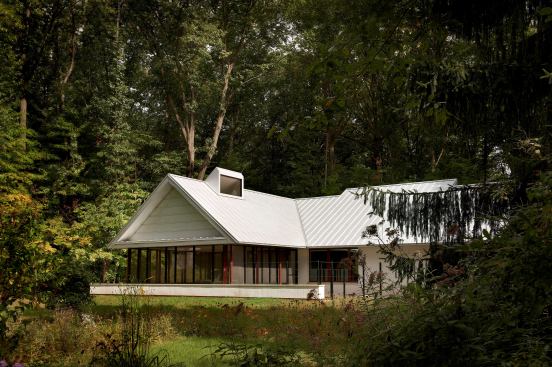 The crisp white stucco and bold red windows of the original house were retained but detailed with an updated sensibility.