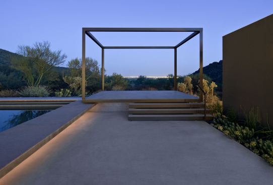 The floating steel cube is elevated a few feet to frame distant views of the city lights to the east and mountain ridgelines across the top of the house. Perched on the site’s southeast corner, the sculptural space is surrounded by the restored desert vegetation.