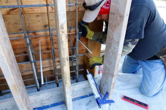 Notice the tape and caulk used to contain the concrete as it wants to seep out onto the existing slab. There is no additional flooring over this slab so great pains have been taken to protect it.