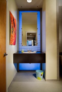 A vibrant back-lit panel adds energy to this bathroom vanity, while a switch in patterns above and below the sink lends texture and interest. Architect: Todd Walker/Scott Guidry, Memphis, Tenn. Builder: EB Construction, Memphis