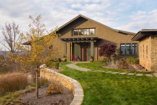 Local stone retaining walls provide a natural link between the outdoor spaces and the wild landscape surrounding the house.