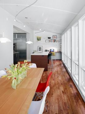 The dining table is positioned along the 40-foot glass wall that helps this house take advantage of its great parkland views. Windows are low-e.