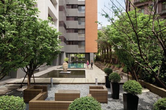 A lush, landscaped courtyard creates an urban oasis in the densely populated city.